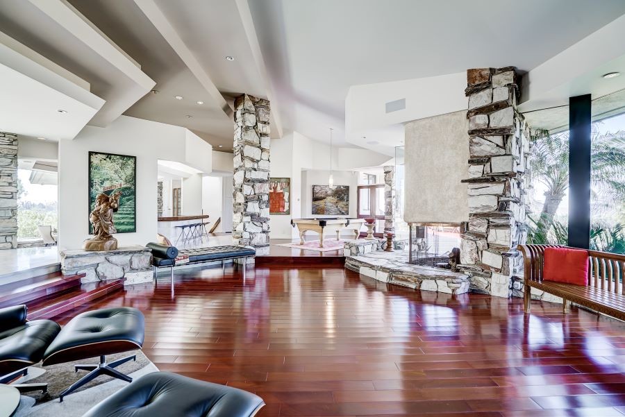 Home with an open floor plan, in-ceiling speakers, rock pillars, and a fireplace.