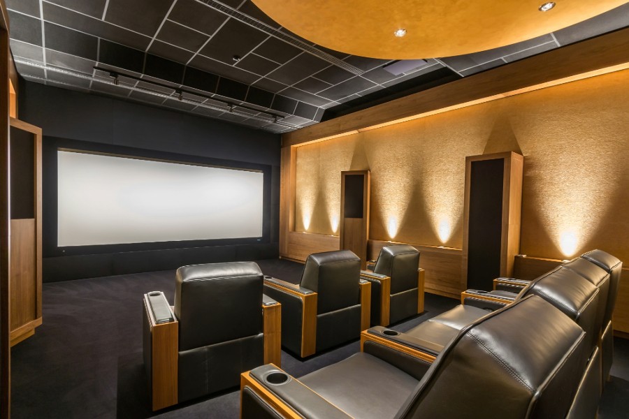  A home theater with black leather recliners.