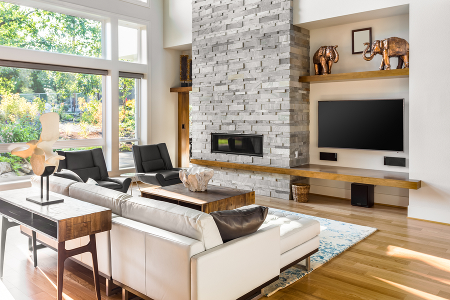 View of a smart living room space, including rolled up shades and a wall-mounted AV system.