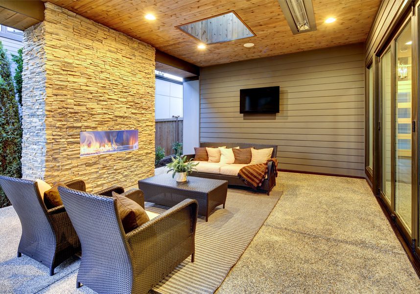 Gorgeous outdoor space with ample seating, recessed lighting, a fireplace, and a television on the wall.