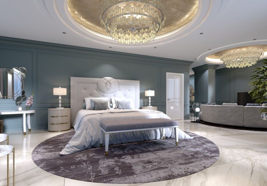 A luxury bedroom with chandeliers and a seating area.