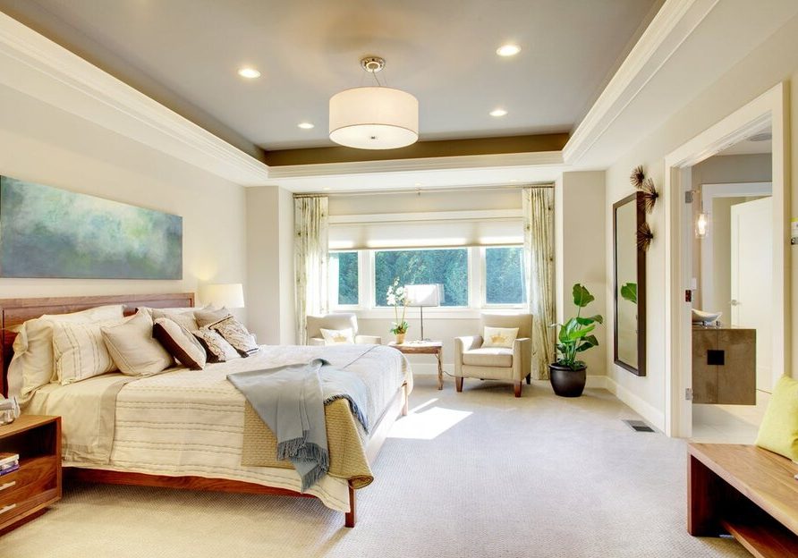 A bedroom with in-ceiling lighting fixtures and an open window with motorized shading.