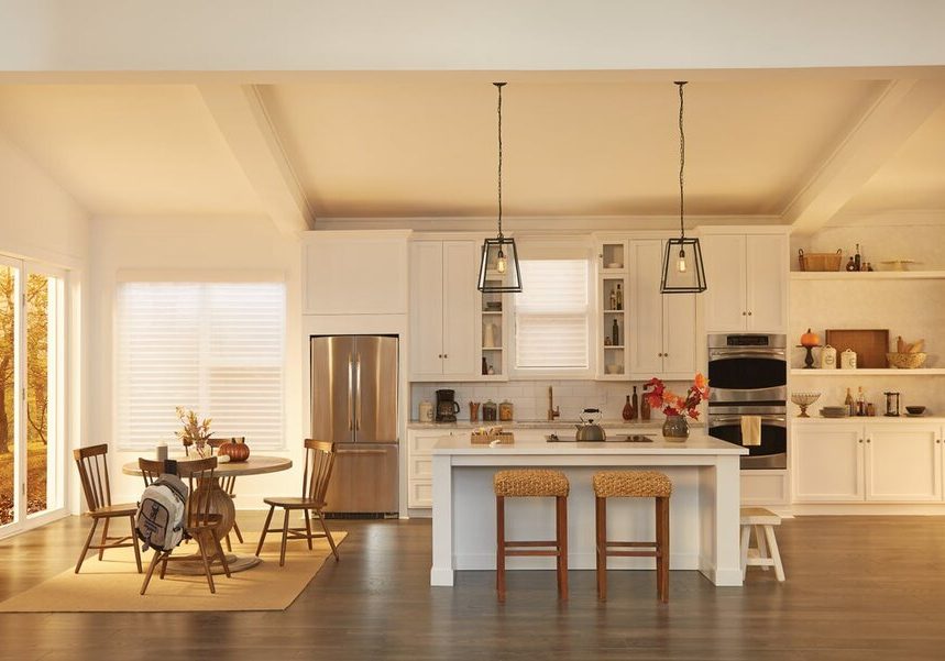 A sunlit kitchen featuring Lutron motorized shades on the windows.