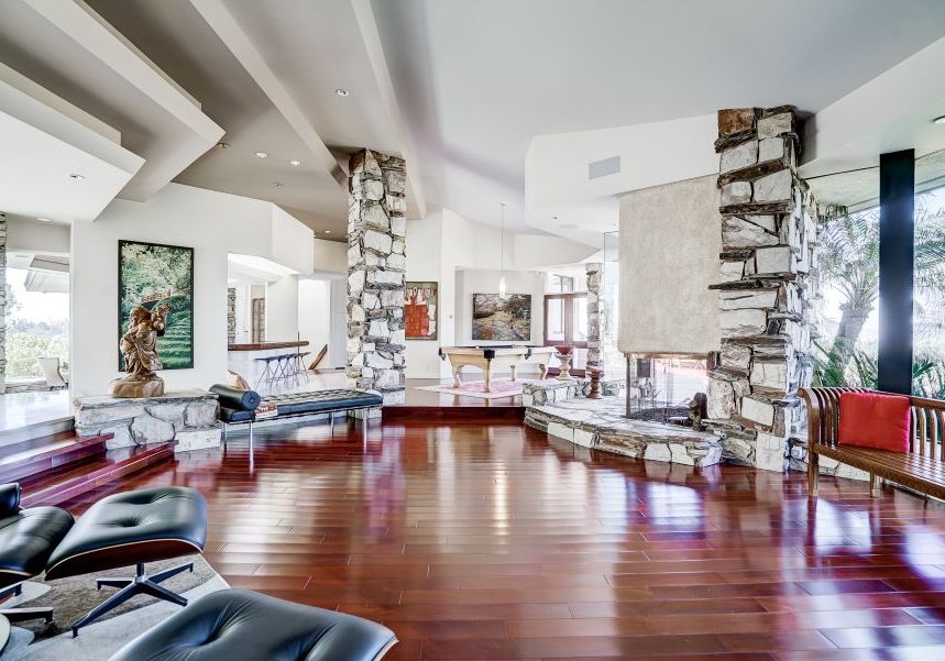 Home with an open floor plan, in-ceiling speakers, rock pillars, and a fireplace.