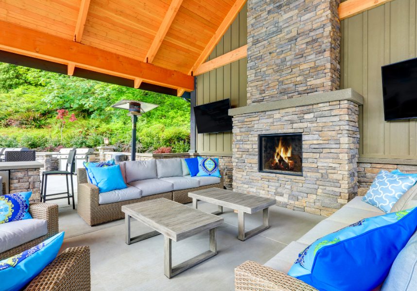 Relaxing patio with furniture, fireplace, and TVs.